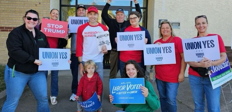 Power in numbers: collection of nurses holding up Stop Trump signs