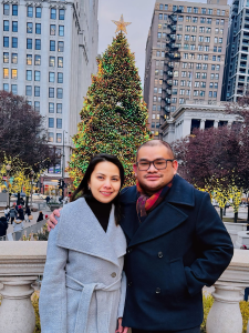 Image of Patrick and Nina standing in front of a decorated Christmas Tree in Chicago, Illinois.